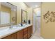 Bathroom featuring double sinks, a large mirror and a walk-in shower at 5599 Hidden Oak Ct, North Port, FL 34287