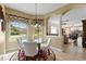 Charming breakfast nook with a glass table and a view into the living room and through the windows at 5599 Hidden Oak Ct, North Port, FL 34287