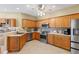 Spacious kitchen with stainless steel appliances, wood cabinets, and tile flooring at 5599 Hidden Oak Ct, North Port, FL 34287