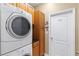 Efficient laundry area featuring stackable washer and dryer, complemented by storage cabinets and a utility sink at 5599 Hidden Oak Ct, North Port, FL 34287