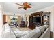 Spacious living room with a ceiling fan, wooden floors, and comfortable seating and dining areas at 5599 Hidden Oak Ct, North Port, FL 34287