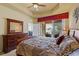 Main bedroom with patio access, a comfortable bed, dresser and carpet at 5599 Hidden Oak Ct, North Port, FL 34287