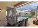 Covered patio with dining table overlooks the pool and spa, perfect for outdoor entertaining and relaxation at 5599 Hidden Oak Ct, North Port, FL 34287