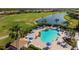 Aerial view of pool and sun-deck at Heron Creek Golf & Country Club overlooking golf course and lake at 5599 Hidden Oak Ct, North Port, FL 34287