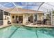 Inviting screened-in pool with a spa, a seating area, and an outdoor grill, perfect for gatherings at 5599 Hidden Oak Ct, North Port, FL 34287