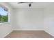 Bright bedroom with a ceiling fan and a large window showcasing outdoor views at 9874 Indian Key Trl # 62, Seminole, FL 33776