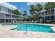 Refreshing community pool with pristine blue water, lounge chairs, and lush landscaping at 9874 Indian Key Trl # 62, Seminole, FL 33776