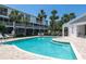 Inviting community pool surrounded by palm trees, lounge chairs, and a well-maintained deck area at 9874 Indian Key Trl # 62, Seminole, FL 33776
