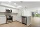 Stylish kitchen features stainless steel appliances, white cabinetry, and an open floor plan at 9874 Indian Key Trl # 62, Seminole, FL 33776