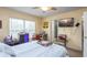 Bedroom with a queen bed, blinds, ceiling fan, TV, and a colorful armchair at 10821 Great Carlisle Ct, Riverview, FL 33578