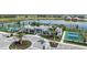 Aerial view showcases the community clubhouse, tennis courts, lush landscaping, and tranquil lake at 18056 Cherished Loop, Bradenton, FL 34211