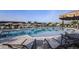 Relaxing community pool area with comfortable lounge chairs, shady umbrellas, and a tranquil lake view at 18064 Cherished Loop, Bradenton, FL 34211