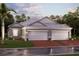 Charming single-story home featuring a three-car garage, well-manicured lawn, and tropical landscaping at 18064 Cherished Loop, Bradenton, FL 34211