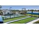 Community bocce ball and pickleball courts are surrounded by lush landscaping, with the pool and lake in the background at 18068 Cherished Loop, Bradenton, FL 34211