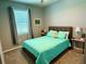 Bedroom featuring neutral gray color palette, a bed with an turquoise quilt, and side tables at 43819 Cattleman Dr, Punta Gorda, FL 33982