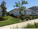 Well-manicured lawn and landscaping surrounding a lovely single-story home with neutral colors at 43819 Cattleman Dr, Punta Gorda, FL 33982