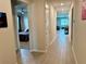 Hallway featuring tile floors, doors, and an open view into other rooms in the home at 43819 Cattleman Dr, Punta Gorda, FL 33982