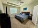 Spacious bedroom featuring tray ceilings, a ceiling fan, and dark wood bedroom furniture at 43819 Cattleman Dr, Punta Gorda, FL 33982