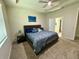 Spacious bedroom featuring tray ceilings, a ceiling fan, and a side table with lamp at 43819 Cattleman Dr, Punta Gorda, FL 33982