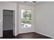 Bright bedroom features hardwood floors, large window, and closet with shelving at 5613 Legacy Crescent Pl # 201, Riverview, FL 33578