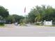 Entrance to community featuring lush greenery, mature trees, and an American flag at 5613 Legacy Crescent Pl # 201, Riverview, FL 33578