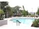 Community pool with lounge chairs, lush landscaping, and nearby residential buildings at 5613 Legacy Crescent Pl # 201, Riverview, FL 33578