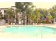 Community pool surrounded by mature landscaping and lounge seating for relaxation and enjoyment at 5613 Legacy Crescent Pl # 201, Riverview, FL 33578