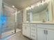 Well-lit bathroom featuring a double vanity, a large mirror, and a glass-enclosed shower at 13610 Wolfpack Rd, Hudson, FL 34667