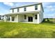 Spacious backyard with a covered lanai, sliding glass doors, ceiling fans and green grass at 13622 Wolfpack Rd, Hudson, FL 34667