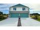 Exterior showcasing a modern two-story home with a two-car garage and tidy landscaping at 13622 Wolfpack Rd, Hudson, FL 34667