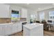 Bright kitchen boasts white cabinets, stainless steel appliances, an island, and seamless access to the dining area at 13978 Emerald Fields Dr, Hudson, FL 34667