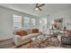 Bright living room features a comfortable sofa, stylish coffee table, and large windows that let in natural light at 14004 Emerald Fields Dr, Hudson, FL 34667
