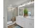 Bathroom boasts dual vanity, quartz countertops, walk in shower, and decorative lighting at 14012 Emerald Fields Dr, Hudson, FL 34667