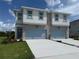Beautiful two-story townhome with stone accents, light blue trim, and a two-car garage at 14012 Emerald Fields Dr, Hudson, FL 34667