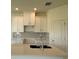 Close up of kitchen featuring an island, stainless sink, and white cabinetry at 14012 Emerald Fields Dr, Hudson, FL 34667