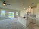 Bright kitchen featuring an island, stainless sink, white cabinetry and an outdoor view at 14012 Emerald Fields Dr, Hudson, FL 34667
