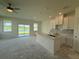 Bright kitchen featuring an island, stainless sink, white cabinetry and an outdoor view at 14012 Emerald Fields Dr, Hudson, FL 34667