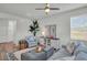 Living room features coastal decor, soft blue arm chair and sofa, and natural light at 14012 Emerald Fields Dr, Hudson, FL 34667