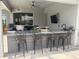 Stylish outdoor kitchen with a bar, seating for four, and integrated appliances for outdoor entertaining at 16617 5Th E Ave, Bradenton, FL 34212