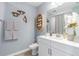 Well-lit bathroom features white vanity, decorative shelving, and stylish wall decor at 16818 Fiesta Dr, Port Charlotte, FL 33953