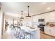 Modern open kitchen featuring white cabinets, stainless steel appliances, and a breakfast bar at 16818 Fiesta Dr, Port Charlotte, FL 33953