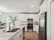Bright eat-in kitchen with a center island, modern stainless steel appliances and white cabinets at 16836 Fiesta Dr, Port Charlotte, FL 33953