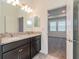 Bathroom featuring double sinks with granite countertops, dark wood cabinets, and view to another room at 16866 Fiesta Dr, Port Charlotte, FL 33953