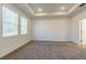 Spacious bedroom featuring neutral carpet, tray ceilings, and natural light from large windows at 16866 Fiesta Dr, Port Charlotte, FL 33953