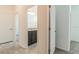 Bright hallway featuring neutral tile flooring, and doorways leading to the bathroom and other rooms at 16866 Fiesta Dr, Port Charlotte, FL 33953