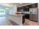 Modern kitchen featuring dark wood cabinets, stainless steel appliances, and granite countertops with an island at 16866 Fiesta Dr, Port Charlotte, FL 33953