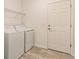 Bright laundry room features a white washer and dryer set, storage shelf and entry door at 16866 Fiesta Dr, Port Charlotte, FL 33953