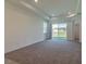 Bright living room with neutral carpet, recessed lighting, and sliding glass door to the backyard at 16866 Fiesta Dr, Port Charlotte, FL 33953