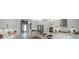 Bright white kitchen features an island with seating, stainless steel appliances, and modern pendant lighting at 1688 Lugano Cir, Nokomis, FL 34275