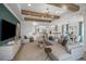 Bright, open-concept living room featuring wood beam ceilings, and contemporary furnishings adjacent to the kitchen and dining room at 1688 Lugano Cir, Nokomis, FL 34275